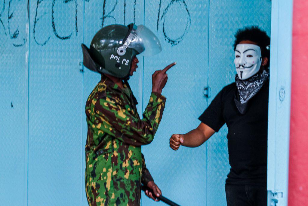 A Kenyan policeman gestures at a protestor wearing a mask in Nairobi, Kenya, on 2 July.