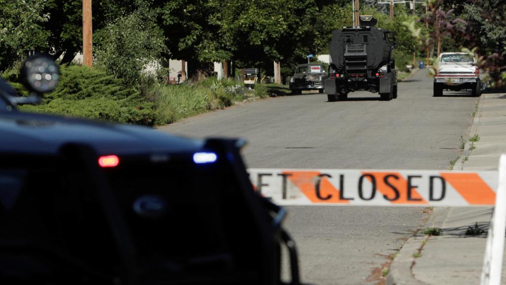 An armored police vehicle travels towards an area where multiple firefighters were attacked when responding to a fire in the Canfield Mountain area outside Coeur d’Alene, Idaho