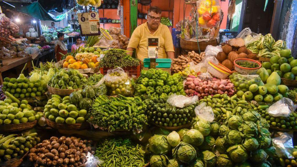 A shop is selling vegetables at a marketplace in Kolkata, India, on July 10, 2024. Prices of tomatoes, onions, and potatoes - staples in every Indian kitchen - are surging by double digits as extreme heat and heavy floods in northern states are disrupting agricultural production, according to reports