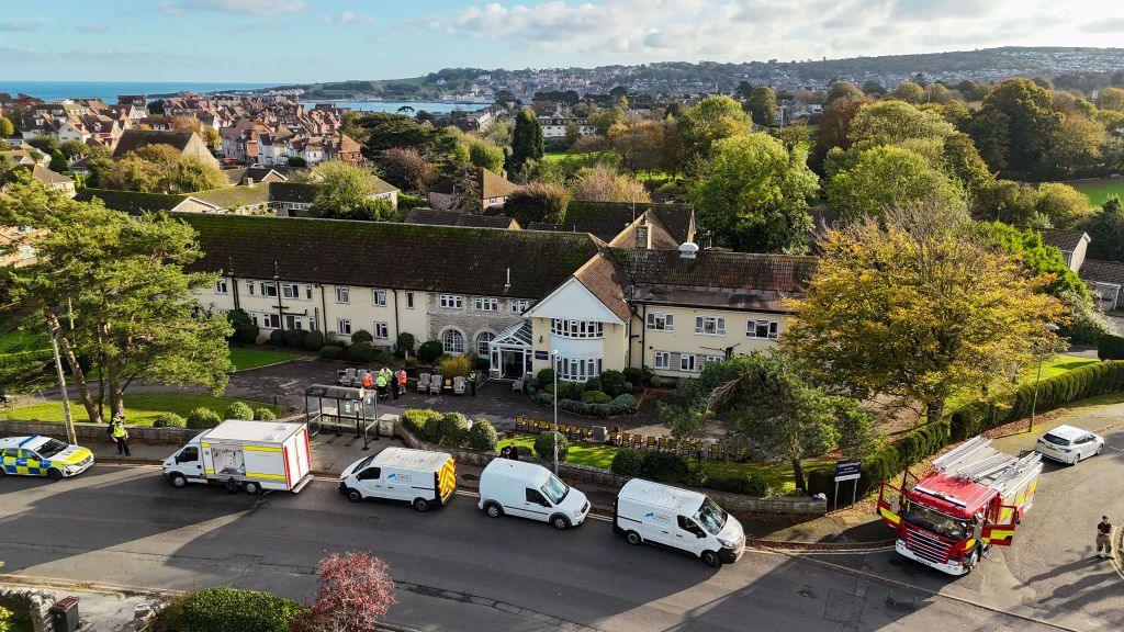 A drone shot of a care home with police vans and a fire engine outside