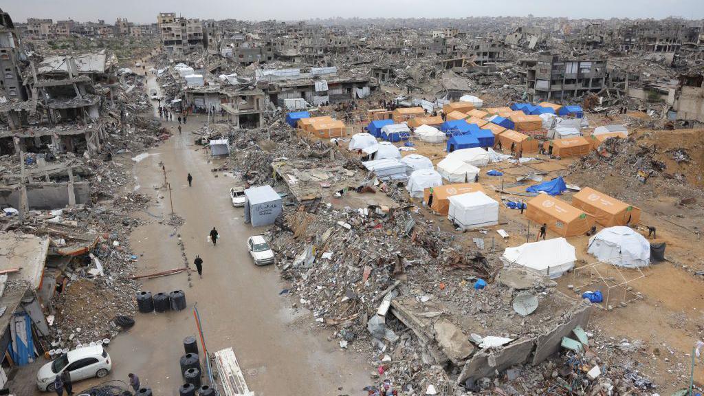 Palestinians shelter in tents set up amid heavily damaged and destroyed buildings in Jabalia, in the northern Gaza Strip (6 February 2025)