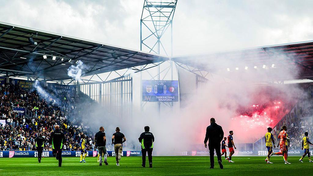 Feyenoord supporters set off fireworks and throw them onto the field and into the stands of SC Cambuur supporters during the Dutch Eredivisie match between SC Cambuur v Feyenoord