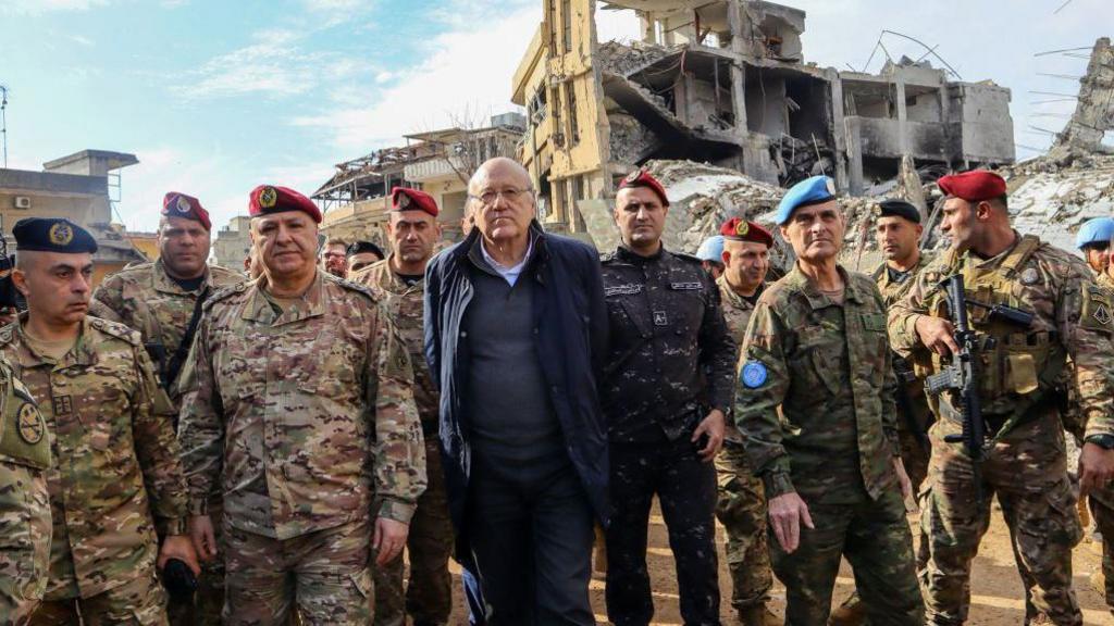 Lebanon's caretaker Prime Minister Najib Mikati (C), Lebanese army commander, General Joseph Aoun (3rd Left), and Major General Aroldo Lazaro, Head of Mission and Force Commander of the United Nations Interim Force in Lebanon (UNIFIL) (2nd Right), visit the southern Lebanese village of Khiam on 23 December 2024