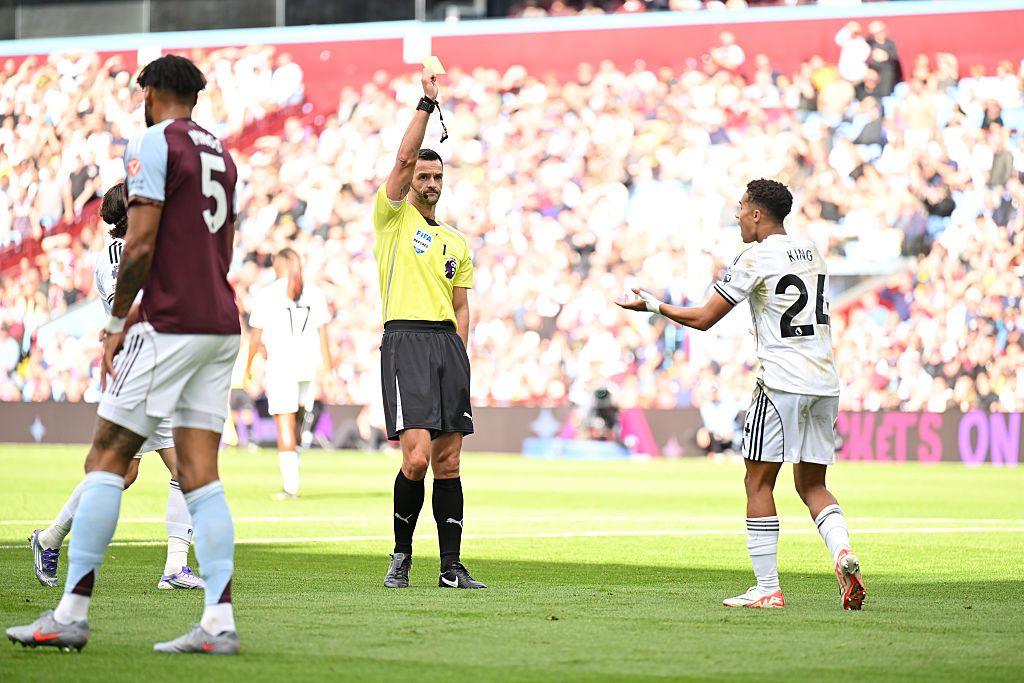 Joshua King of Fulham reacts after being shown a yellow card by referee Andrew Madley