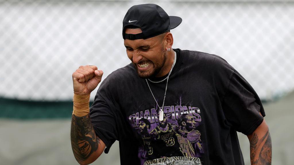 Nick Kyrgios holds up his fist to celebrate a win