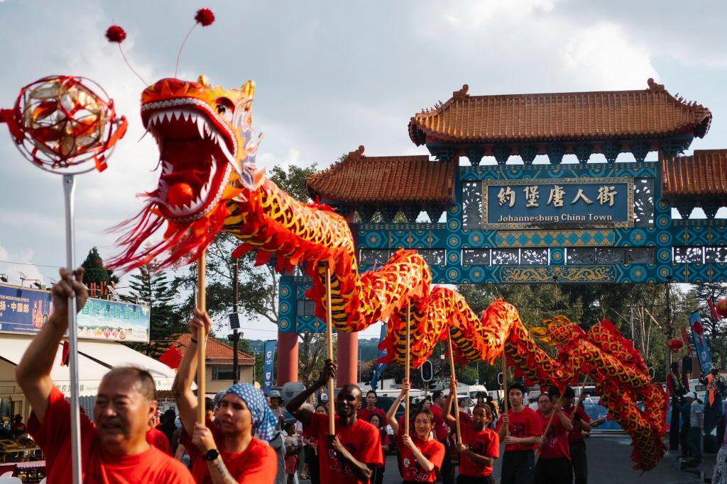 A dance troupe holding a float of a dragon weave it through the streets in Johannesburg, South Africa - Saturday 8 February 2025.