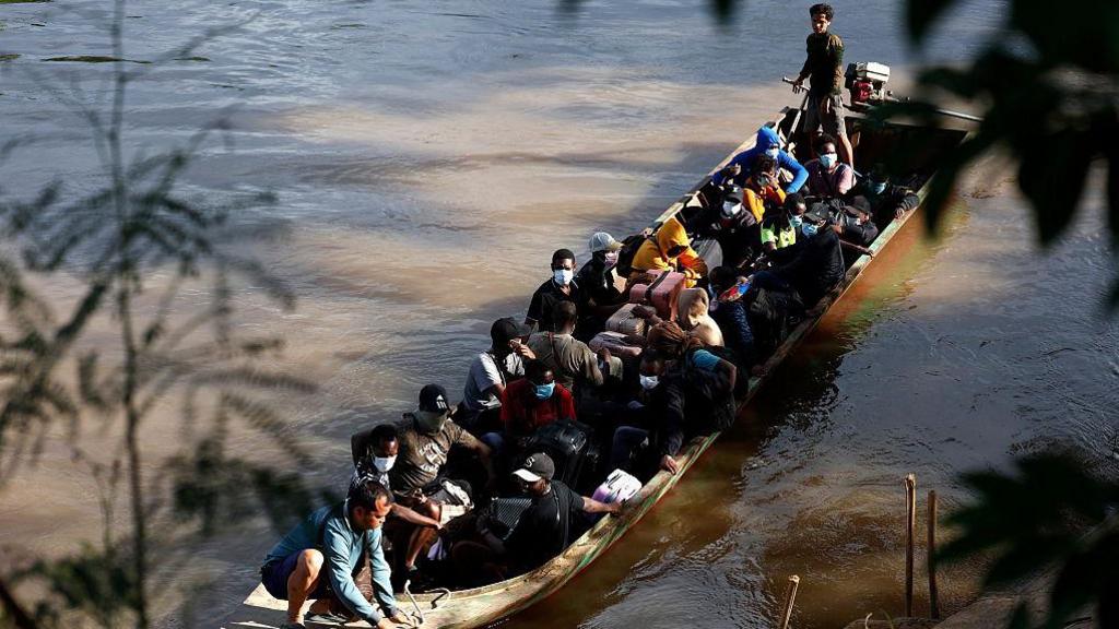 Overhead shot of overcrowded wooden boat over a river