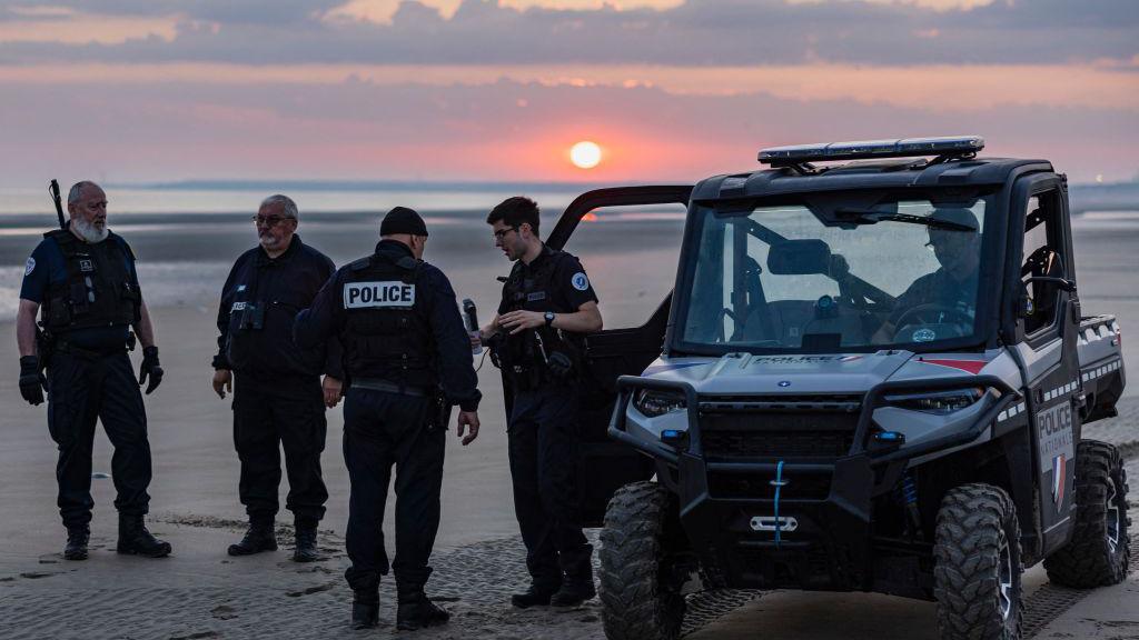 Police force on a beach in France, working to stop migrants from crossing in small boats