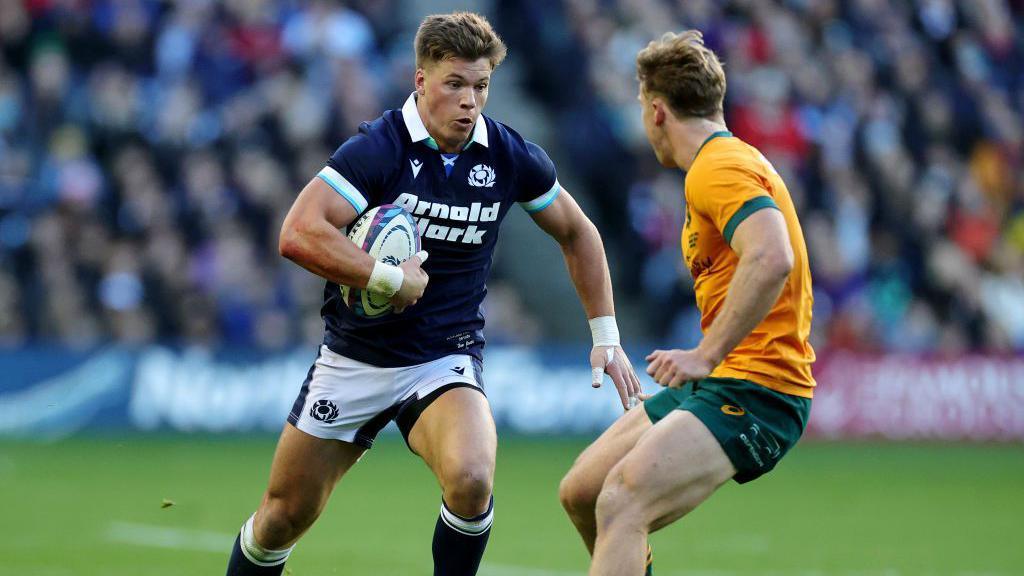 Huw Jones runs with the ball