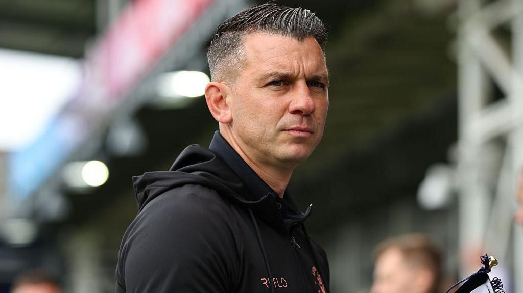 Luton head coach Matt Bloomfield, dressed in a black hooded jacket