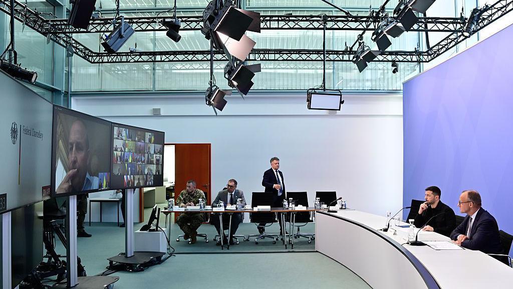 Ukrainian President Volodymyr Zelensky and German Chancellor Friedrich Merz face a screen during a video conference of European leaders with the US President on the Ukraine war ahead of the summit between the US and Russian leaders