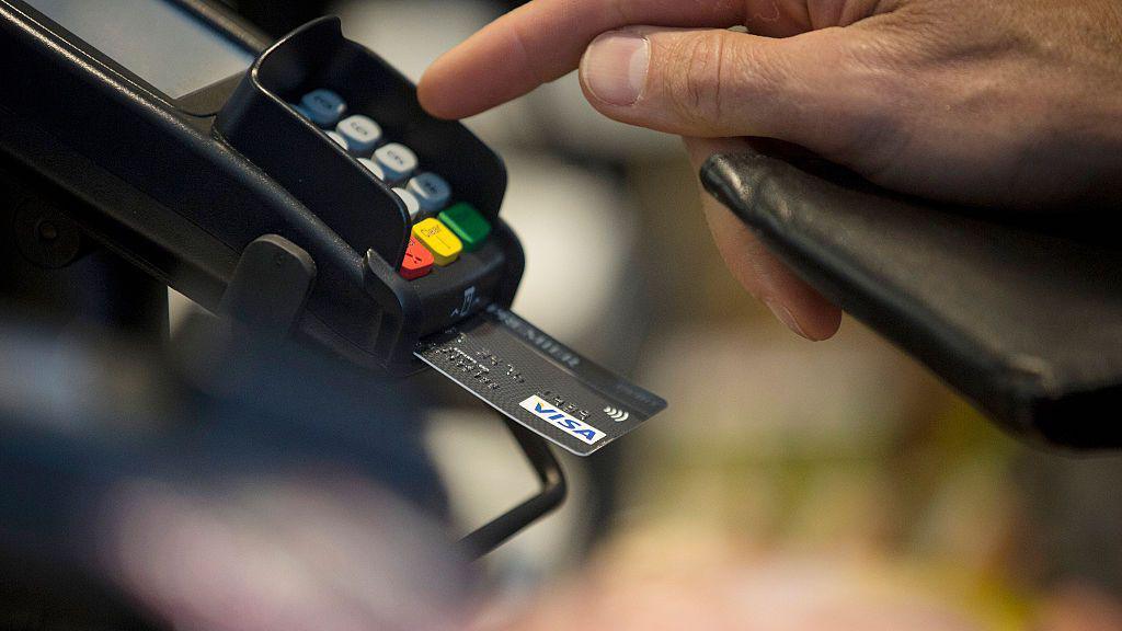 Finger hovering over a card payment machine 