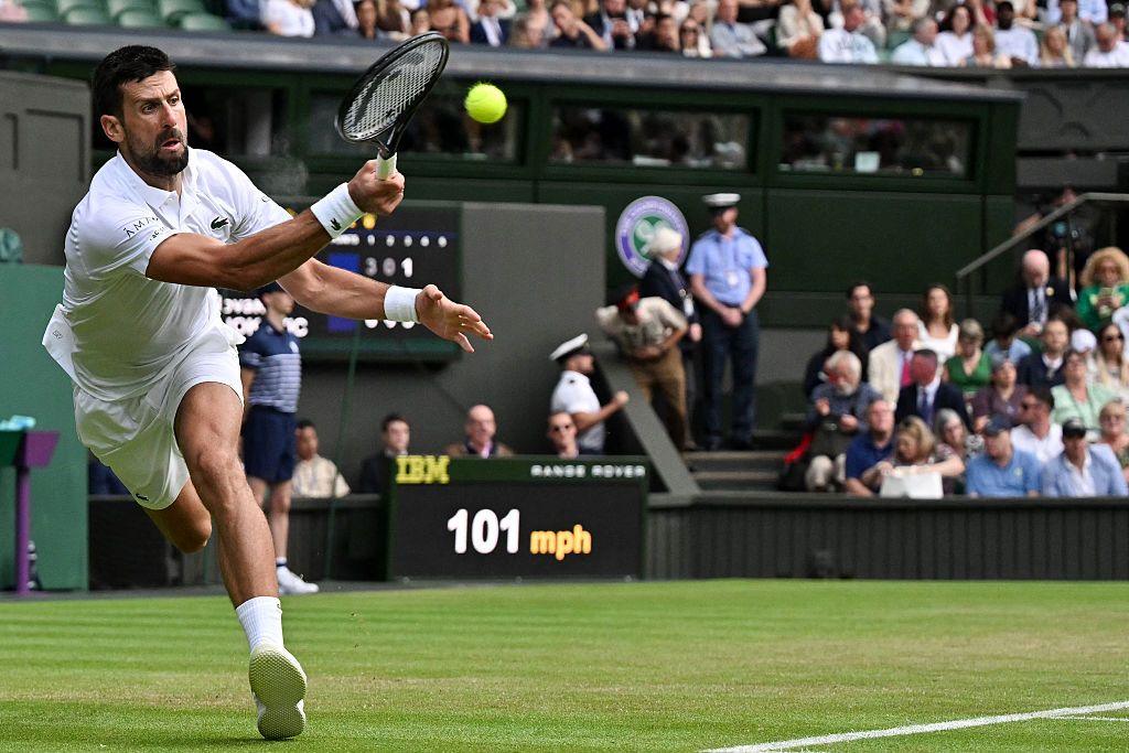 Novak Djokovic se extiende para hacer un tiro de derecha con su brazo derecho durante su tercera ronda contra Miomir Kecmanovic en la cancha central de Wimbledon en 2025.