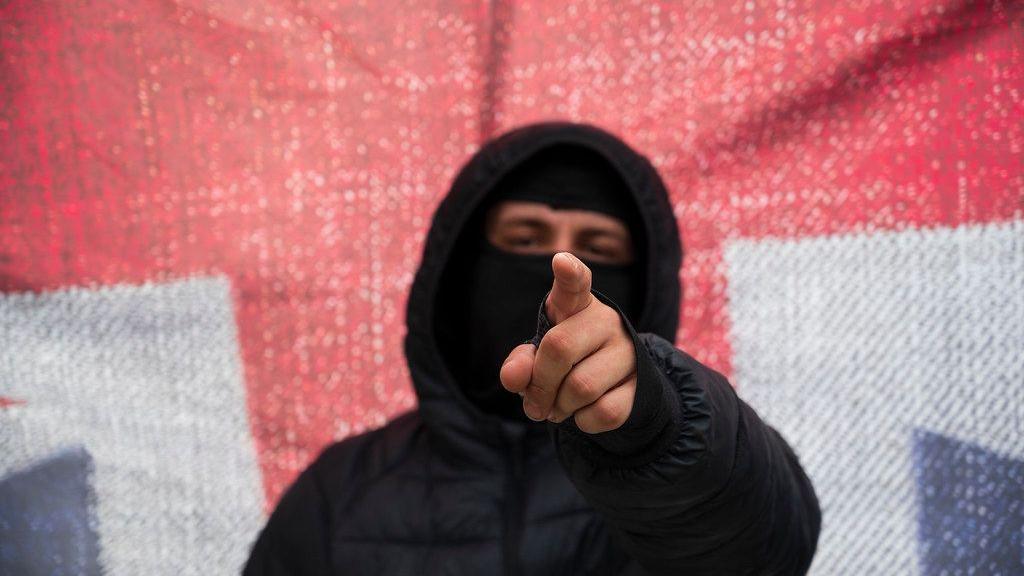 A masked protester in front of a Union Jack in Nottingham