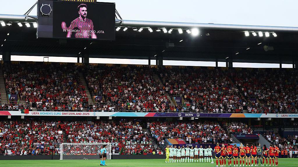 The big screen displays a image of Diogo Jota, as players of Spain and Portugal pause for a short silence 