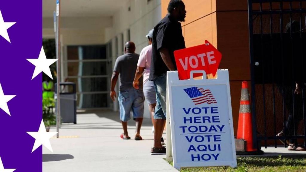 A person walks up to an early voting booth. The words 'Vote here today' is written in English and Spanish