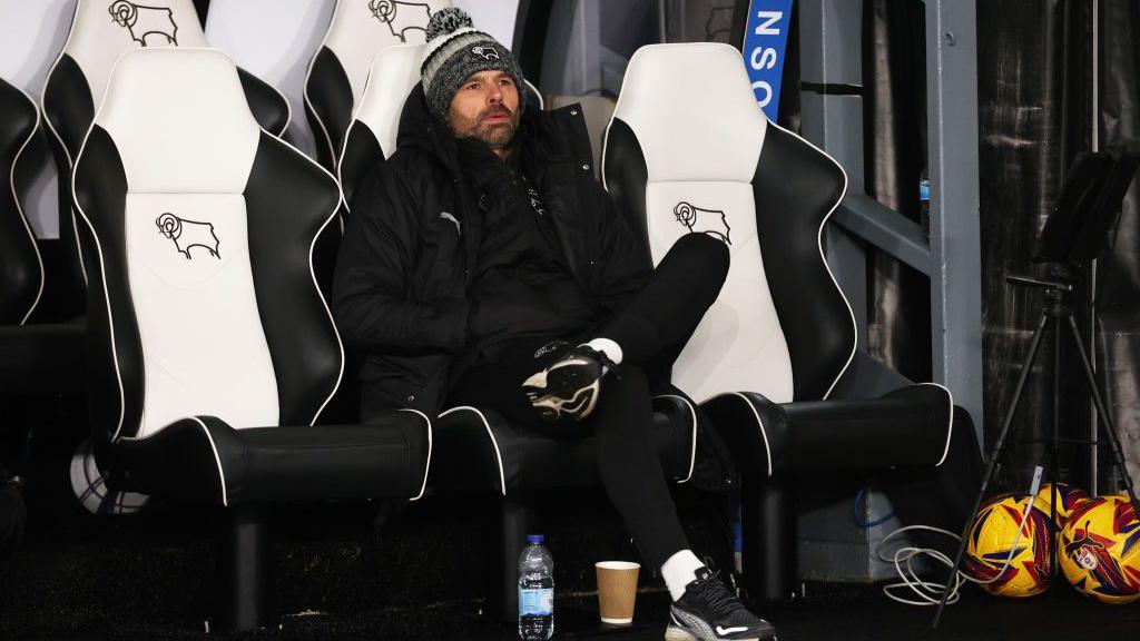 Derby County head coach Paul Warne leans back in his leather bucket seat in the home dug out during a match