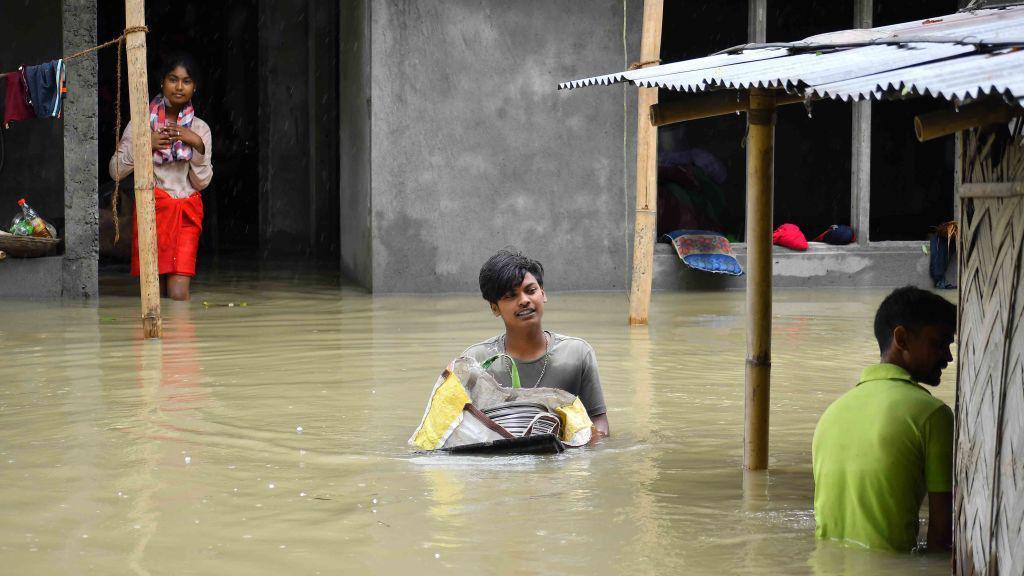 People are shifting their belongings to a safer place following a heavy rainfall in Nagaon District of Assam, India, on July 1, 2024. (Photo by Anuwar Hazarika/NurPhoto via Getty Images)