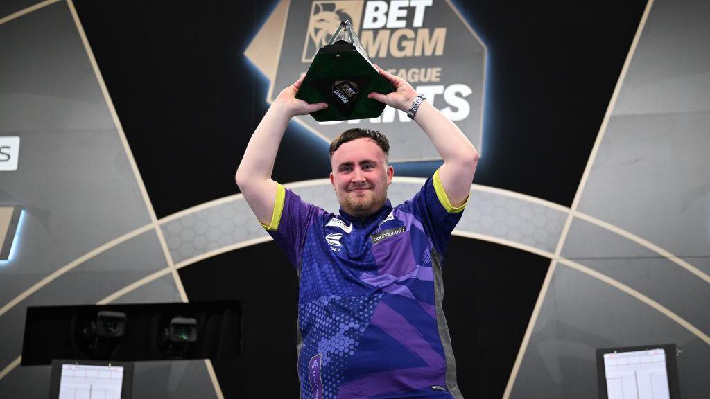 Luke Littler holds the Premier League of Darts trophy