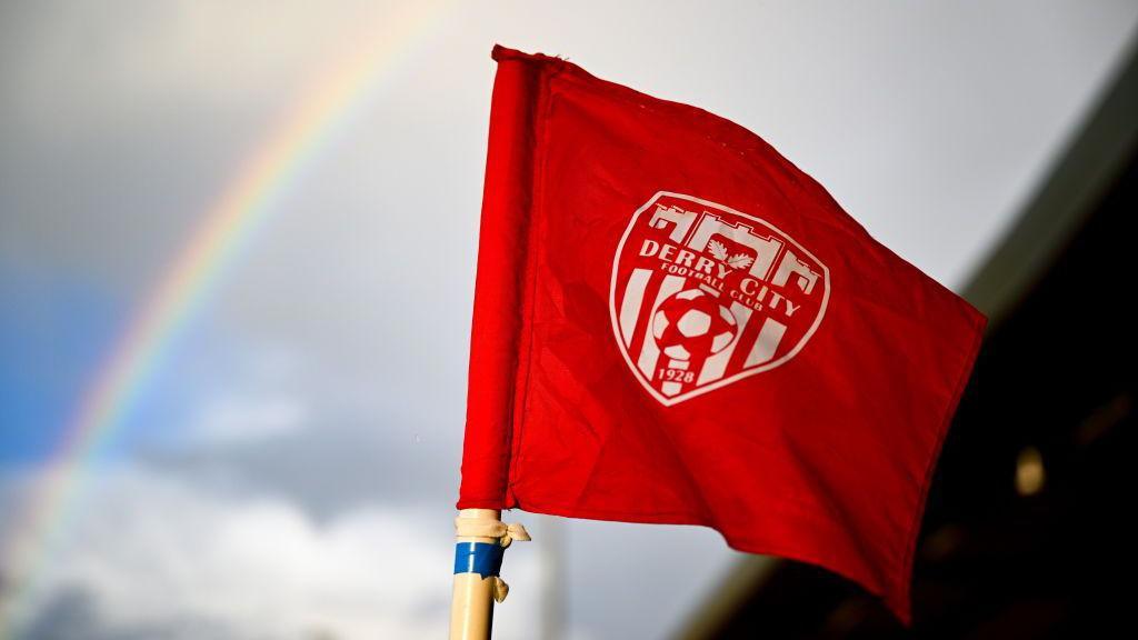 Derry City flag with rainbow in background