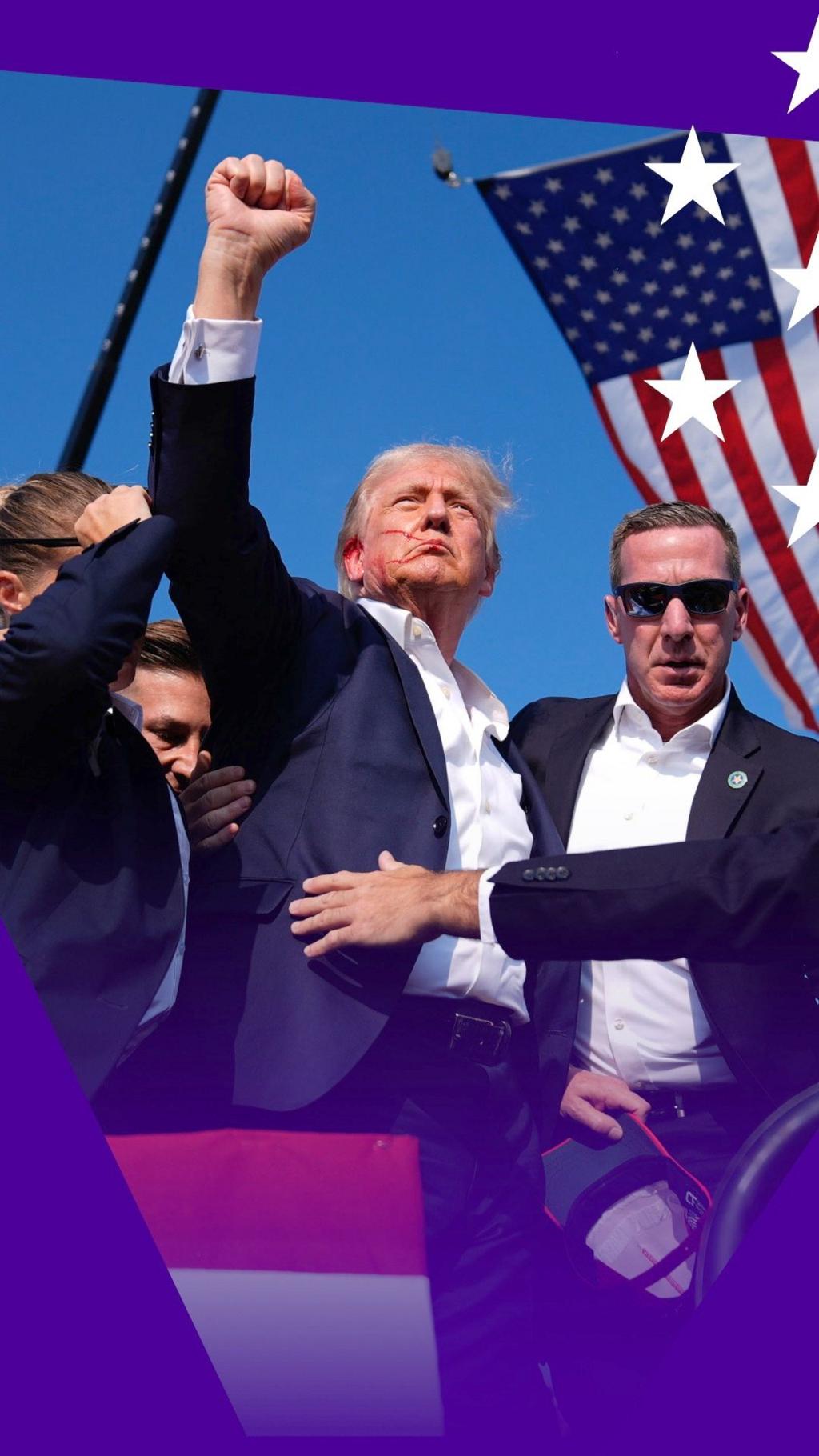 An injured Donald Trump raises his fist while he's escorted off the stage by two men