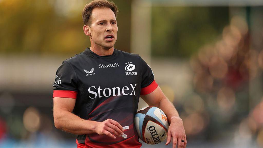 Ivan van Zyl holds a rugby ball under his arm