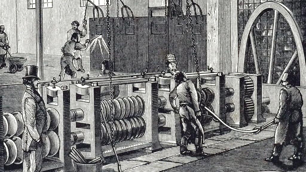 A black and white illustration of iron being produced in Dowlais in the 19th Century. A man in a top hat and suit watches men at work wearing protective visors standing by a long piece of machinery.