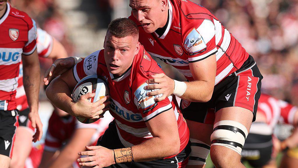 Hugh Bokenham scrambles to his feet with the ball for Gloucester