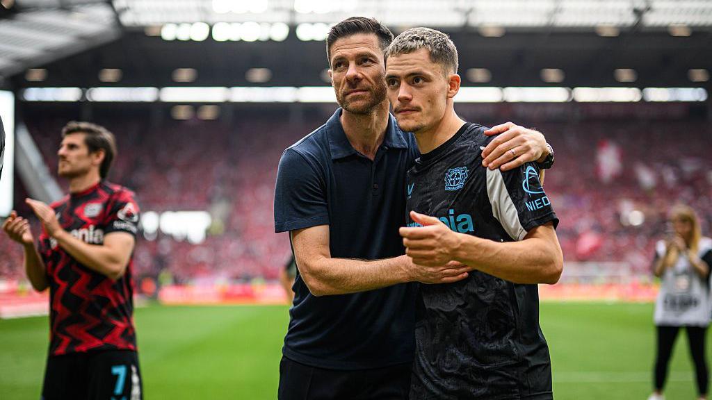 An image of Xabi Alonso of Leverkusen gives Florian Wirtzi a hug after the Bundesliga match between 1. FSV Mainz 05 and Bayer 04 Leverkusen