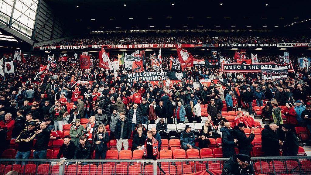 Manchester United fans in a stand supporting the team