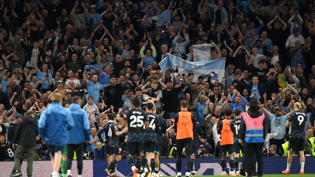 Manchester City players and fans celebrate beating Tottenham