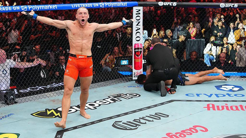 Paddy Pimblett celebrates with Benoit Saint-Denis unconscious and being tended to by the referee behind him