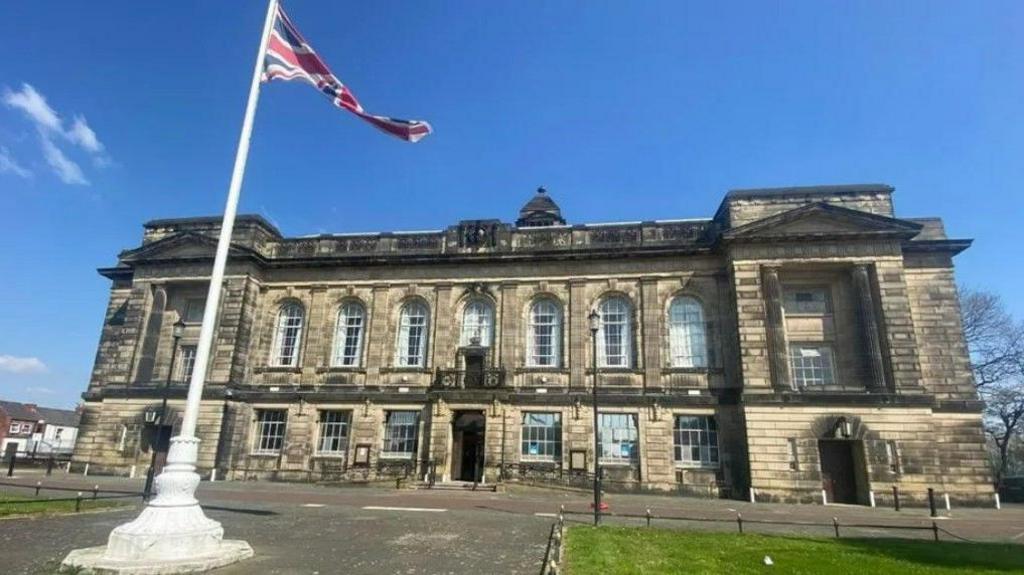 Wallasey Town Hall, with the union jack flag on a flag pole in front of the building.