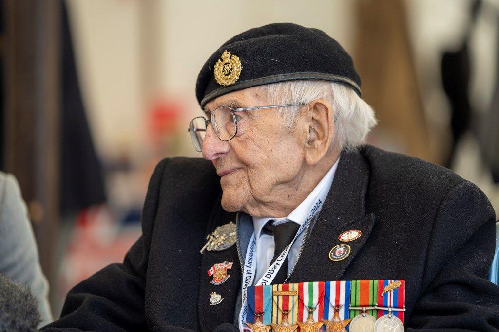 Don wearing his medals, glasses, and smartly dressed as he listens to a memorial service