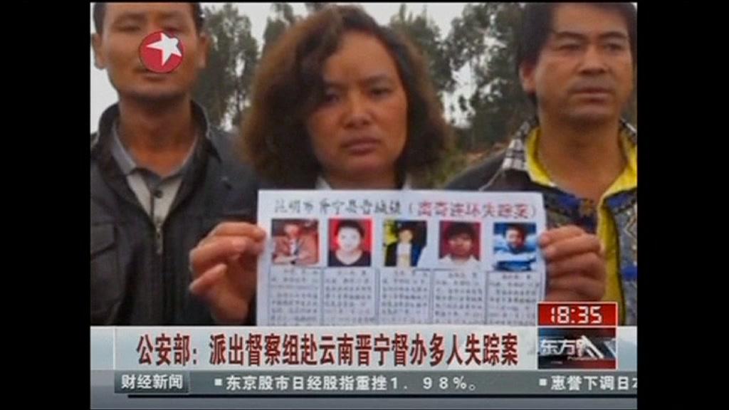 China killings - woman holds up poster