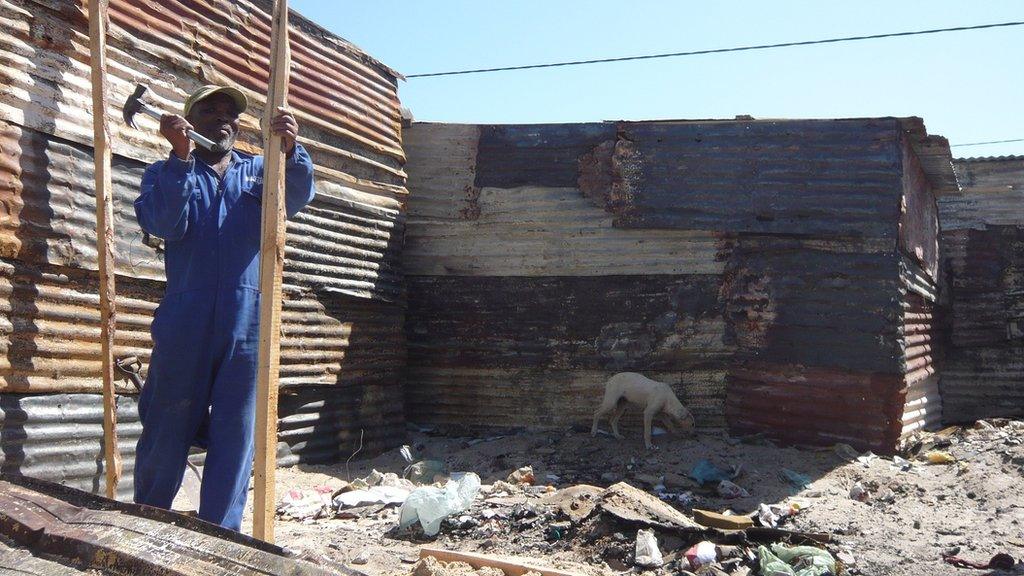 A man rebuilding a shack in Khayelitsha