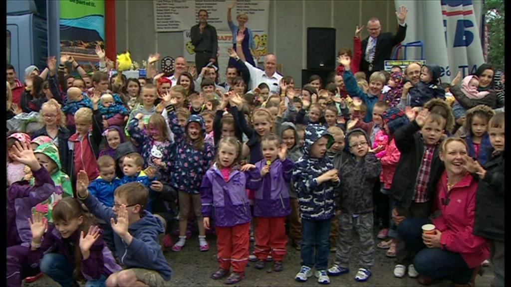 A large group of twins and triplets all waving