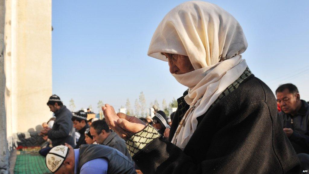 A Kyrgyz woman praying alongside a group of men in Bishkek, Kyrgyzstan.