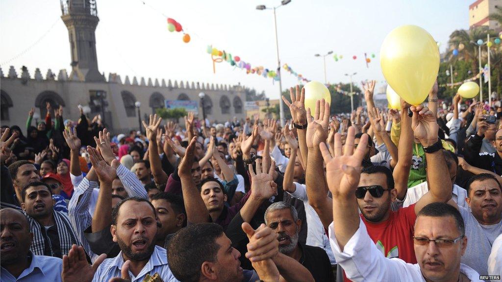 Anti-government protestors gesture and shout anti-military slogans outside a mosque in Cairo.