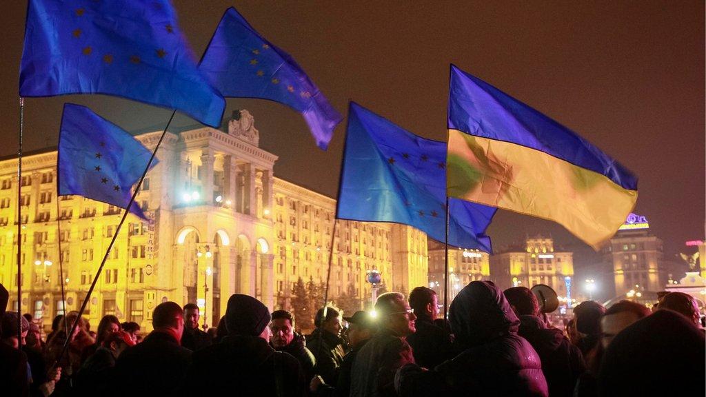 Protesters hold Ukrainian and European Union flags during a rally to support euro integration in central Kiev, 21 November 2013