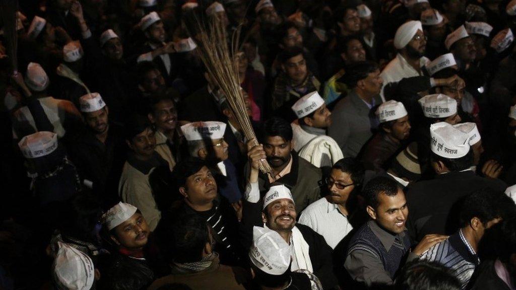 A supporter of Delhi"s Chief Minister Arvind Kejriwal, chief of the Aam Aadmi (Common Man) Party (AAP), holds a broom, the party symbol, at the party headquarters in New Delhi February 14, 2014