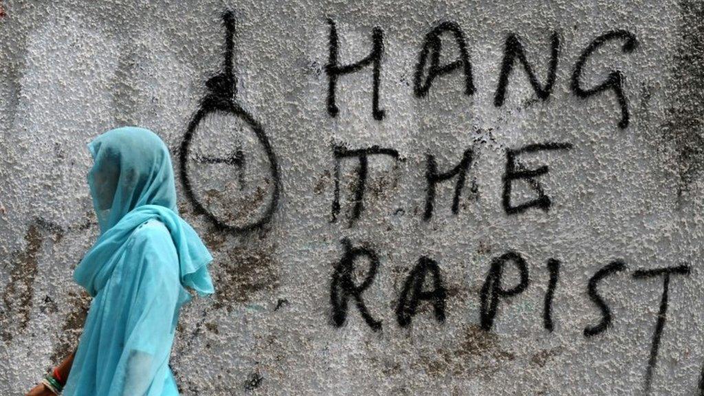 In this photograph taken on April 22, 2013, an Indian pedestrian walks past graffiti against rape written on a wall in New Delhi.