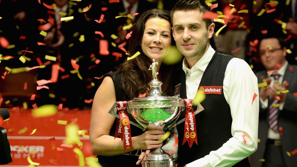 Mark Selby lifts the trophy with wife Vikki after winning The Dafabet World Snooker Championship