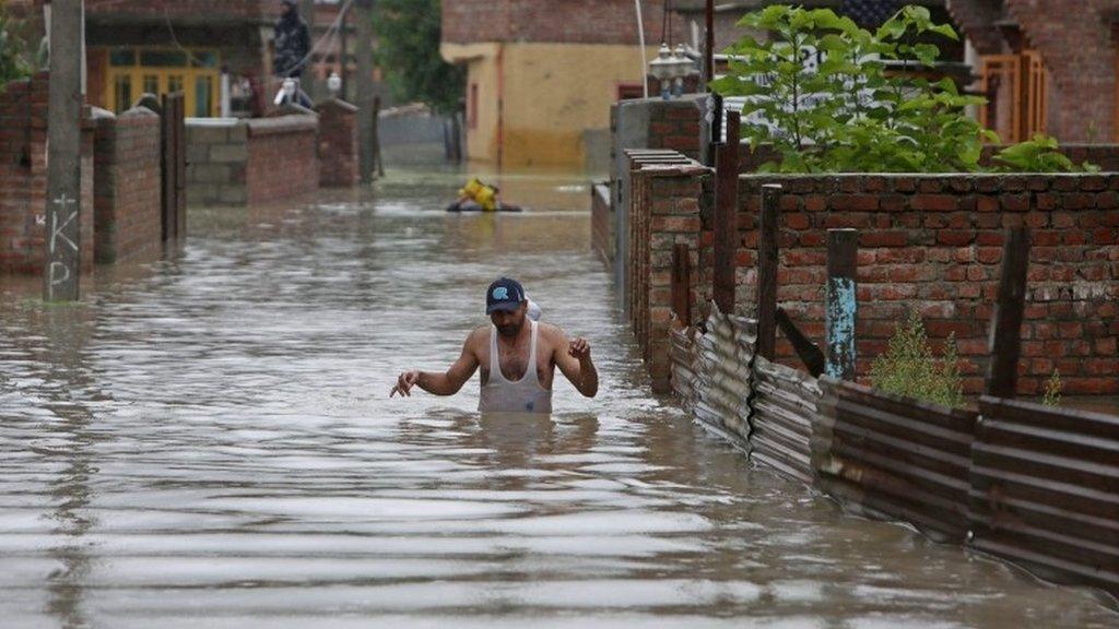 A Kashmiri man wades through flood water in the outskirts of Srinagar, the summer capital of Indian Kashmir on 04 September 2014.