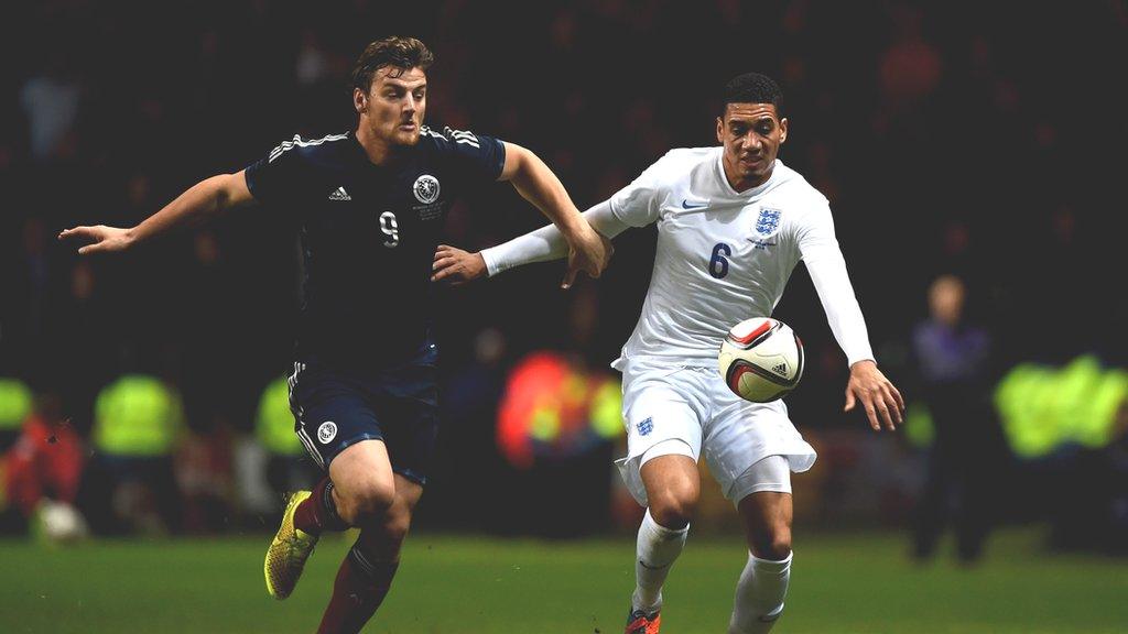 Chris Martin battles for possession with England's Chris Smalling