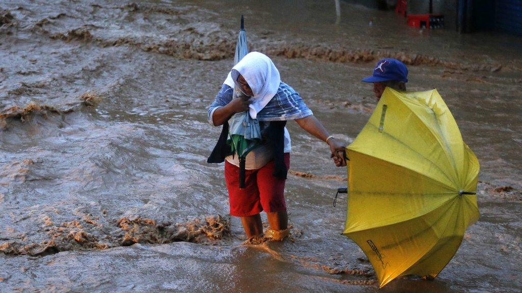 Filipino residents wade on floodwater in Borongan city, Samar island, Philippines, 07 December 2014