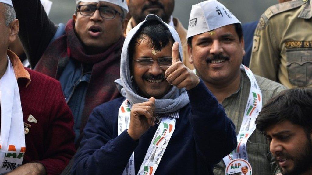 Aam Admi Party (AAP) party chief Arvind Kejriwal greets supporters during a road show in New Delhi on January 20, 2015