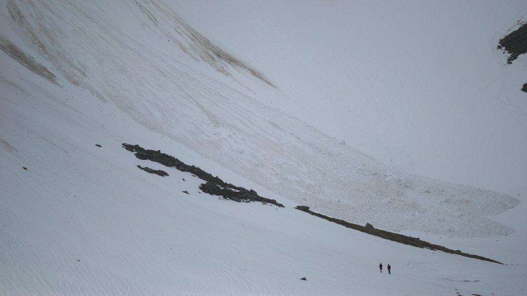 Men looking at avalanche debris