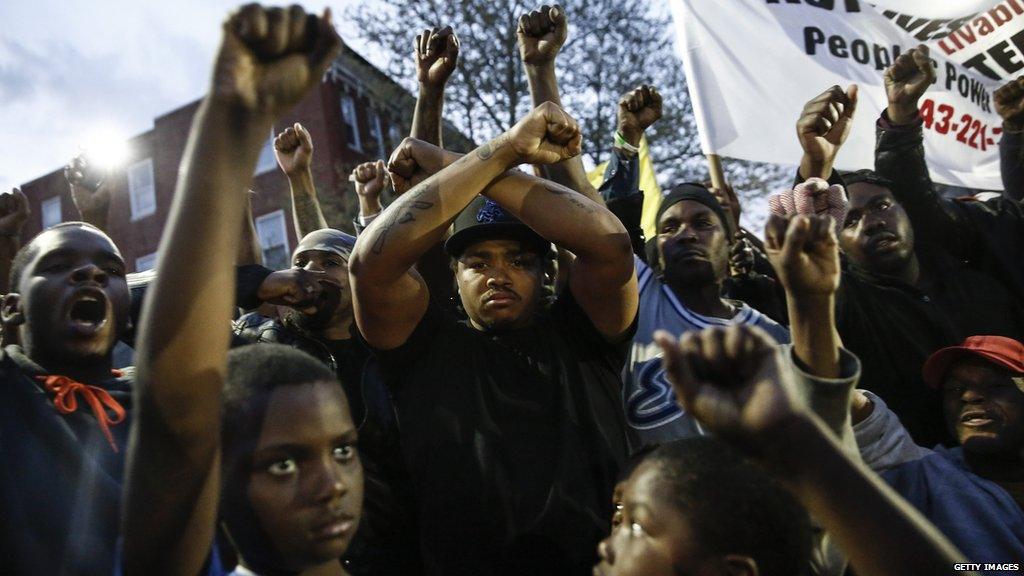 Demonstrators hold up their hands at a protest