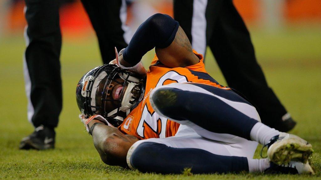 David Bruton holds his head while lying on the ground